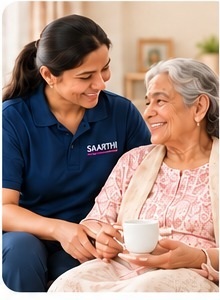 A Saarthi companion sitting with an elderly woman enjoying tea at home